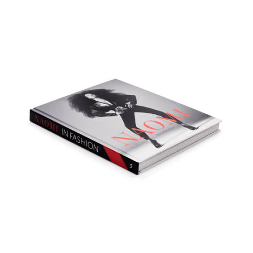 Book cover of Naomi: In Fashion. It features a black and white photo of a model posing in front of the camera. The book title is in right red capital letters.